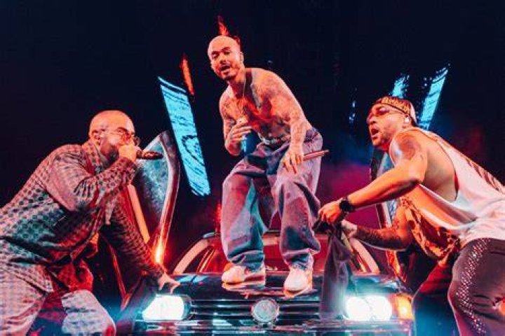 J Balvin posing alongside monkeys